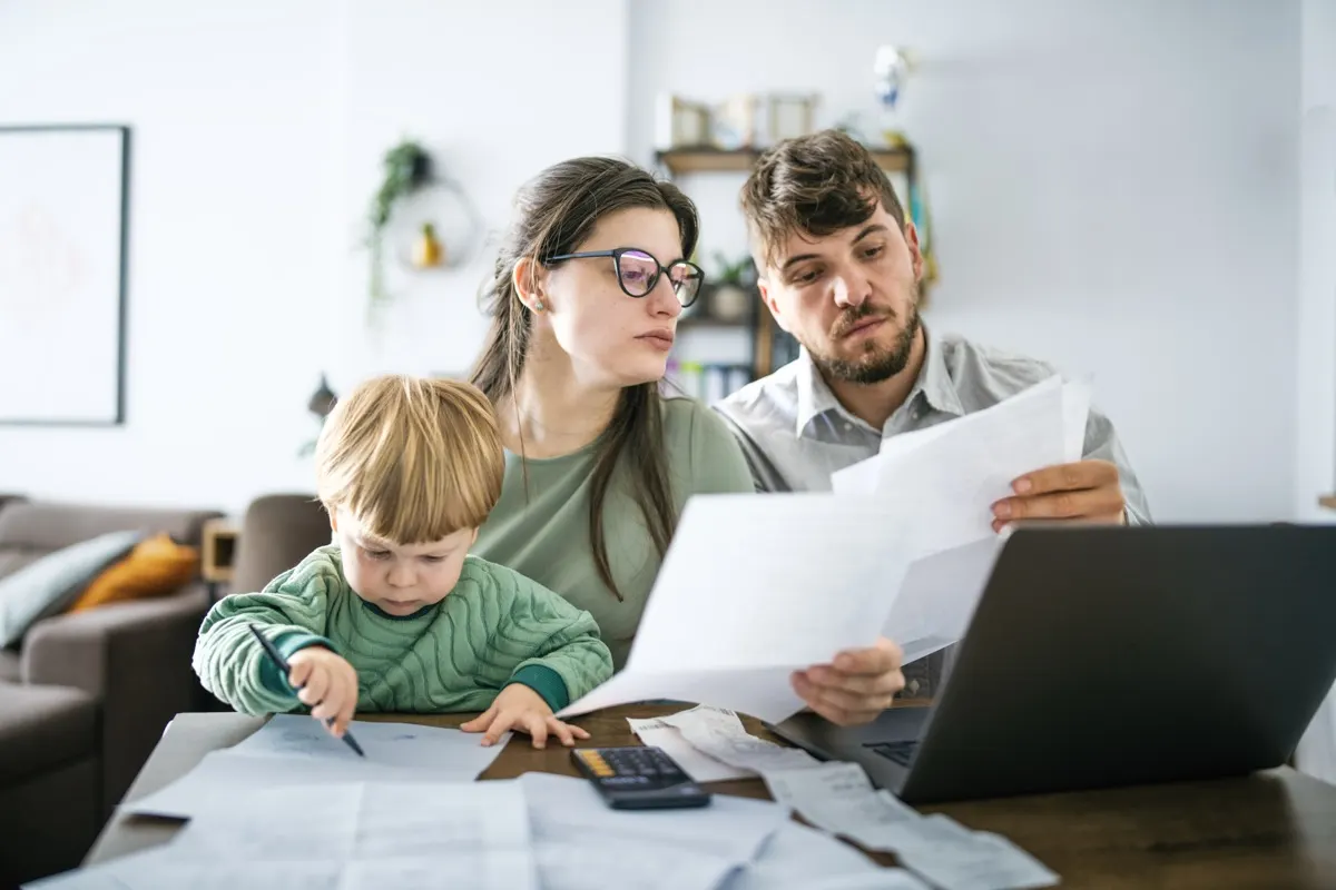 Parents reviewing bills at home with their child